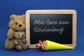 Tafel mit der Aufschrift "Alles Gute zum Schulanfang", ein Teddy und eine Schultüte